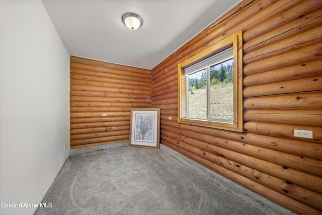 unfurnished room featuring carpet flooring and rustic walls