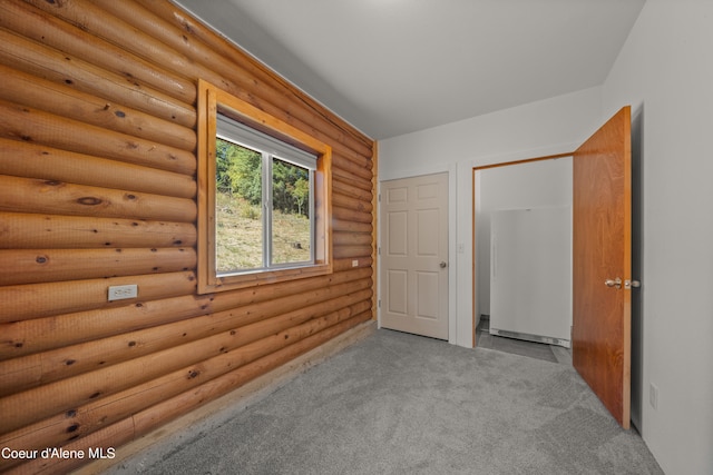 carpeted spare room with rustic walls