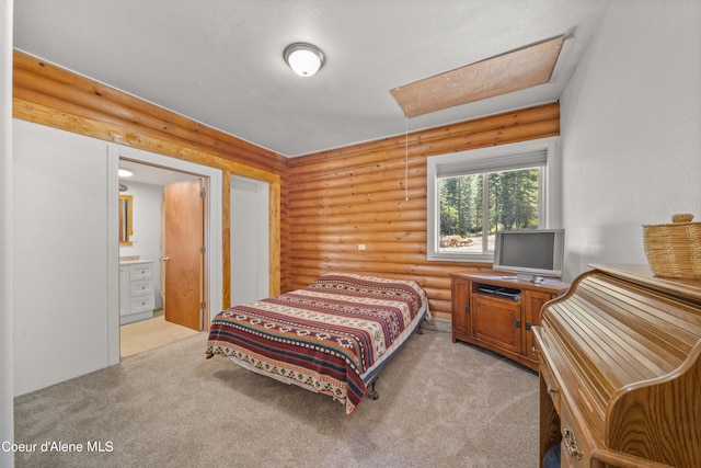 bedroom featuring light colored carpet, a textured ceiling, connected bathroom, and log walls