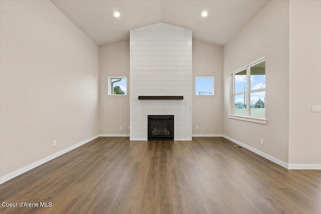 unfurnished living room with a fireplace, hardwood / wood-style floors, and high vaulted ceiling