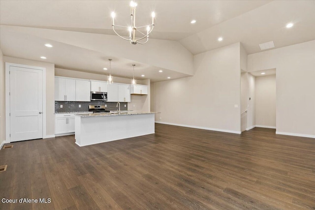 kitchen featuring appliances with stainless steel finishes, decorative light fixtures, a center island with sink, dark hardwood / wood-style floors, and white cabinetry