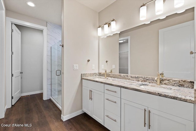 bathroom featuring wood-type flooring, vanity, and an enclosed shower