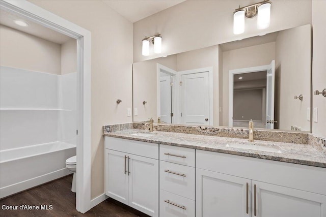 full bathroom featuring wood-type flooring, vanity, toilet, and tub / shower combination