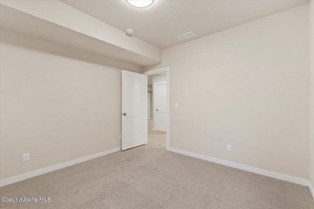 spare room featuring light colored carpet