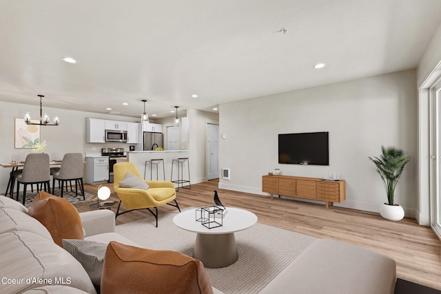 living area with recessed lighting, baseboards, and light wood-style floors