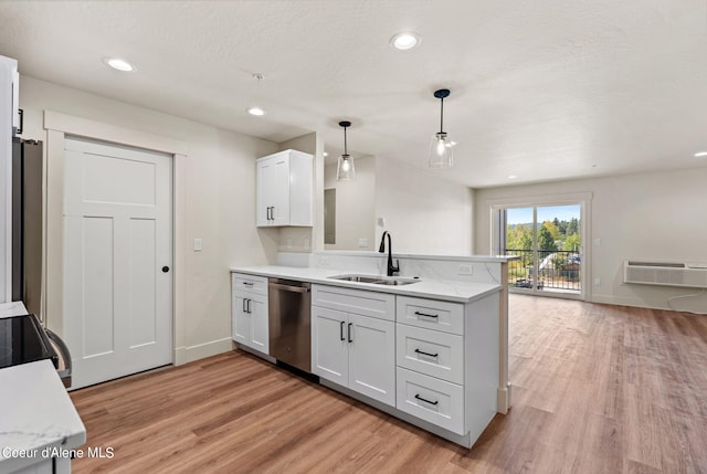 kitchen with dishwasher, a peninsula, light wood finished floors, and a sink