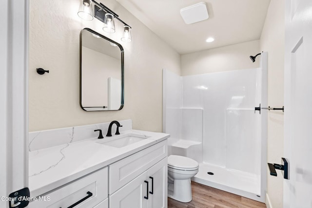 full bath with a shower, toilet, wood finished floors, and vanity