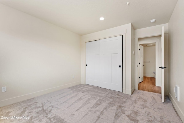 unfurnished bedroom featuring a closet, visible vents, baseboards, and carpet floors