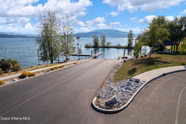 water view featuring a mountain view and a dock