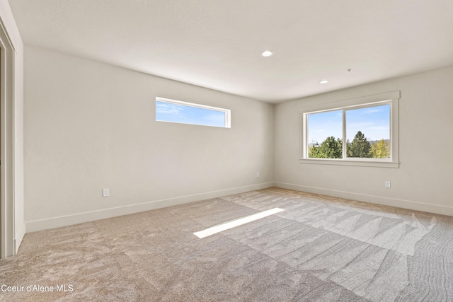 spare room with baseboards, plenty of natural light, and carpet flooring