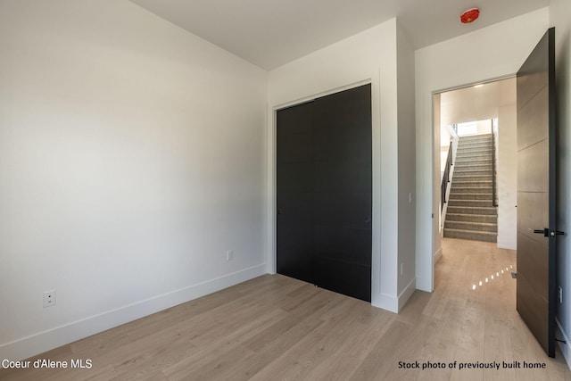 unfurnished bedroom featuring light wood-type flooring and a closet