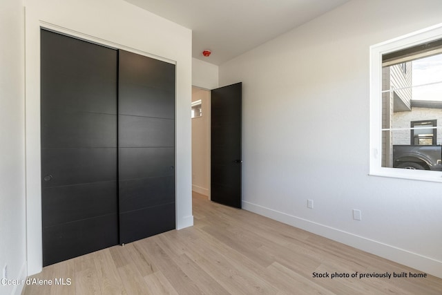 unfurnished bedroom featuring light hardwood / wood-style flooring and a closet