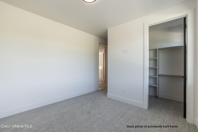 unfurnished bedroom featuring light colored carpet and a closet