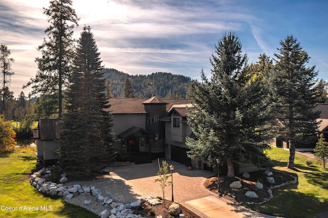 exterior space featuring a lawn, a garage, and a mountain view