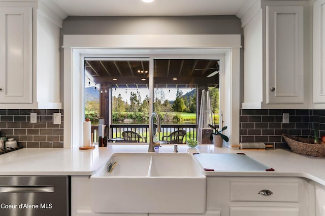 kitchen with light countertops, a healthy amount of sunlight, stainless steel dishwasher, and a sink