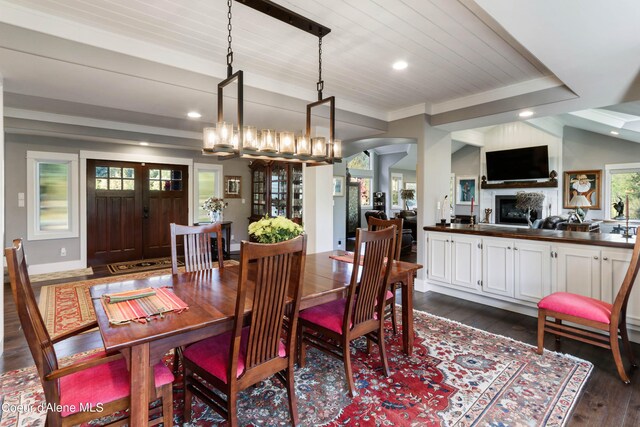 dining area with ornamental molding, dark hardwood / wood-style floors, wooden ceiling, an inviting chandelier, and vaulted ceiling