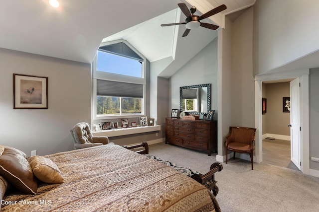 carpeted bedroom featuring baseboards, high vaulted ceiling, and a ceiling fan