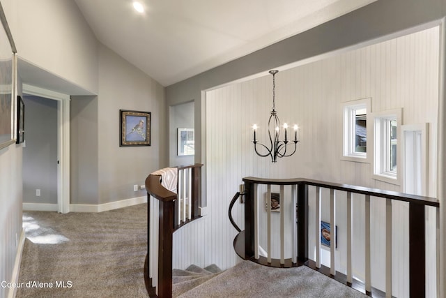 stairs with a chandelier, baseboards, vaulted ceiling, and carpet floors