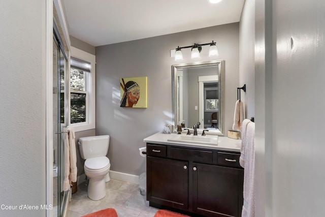bathroom featuring tile patterned flooring, vanity, baseboards, and toilet
