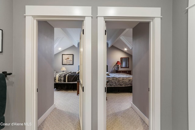corridor featuring baseboards, light carpet, and lofted ceiling