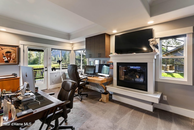 home office featuring a glass covered fireplace, baseboards, recessed lighting, a raised ceiling, and light colored carpet