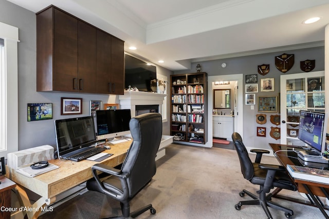 home office with crown molding, recessed lighting, a glass covered fireplace, and light carpet