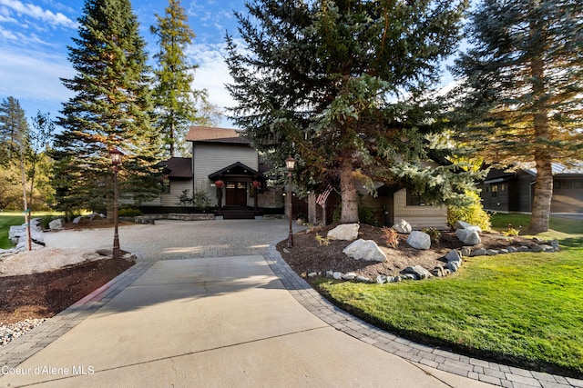 view of front of house featuring a front yard and a shingled roof