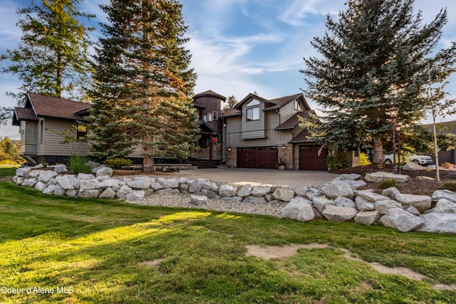 view of front of home featuring concrete driveway, stone siding, an attached garage, a front yard, and a shingled roof