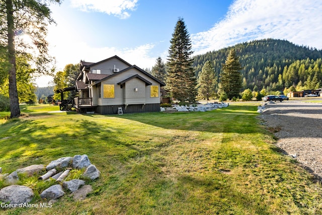 view of property exterior featuring a yard and a forest view