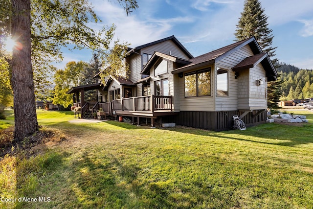 back of house featuring a deck and a lawn