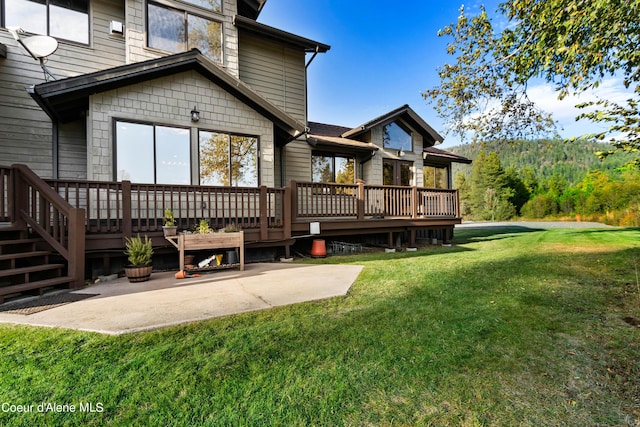 rear view of house with a patio, a yard, and a wooden deck