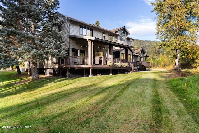 back of property with a yard and a wooden deck