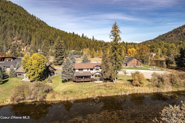 exterior space with a wooded view and a water view