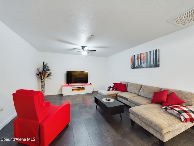 living room featuring ceiling fan and a textured ceiling