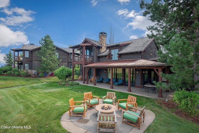 17021 S Citrine Dr, Coeur Dalene, ID 83814 - rear view of house with a chimney, a balcony, a yard, an outdoor living space with a fire pit, and a patio