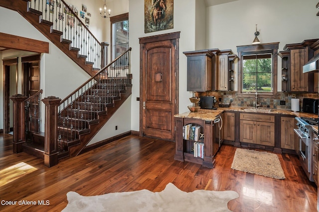 17021 S Citrine Dr, Coeur Dalene, ID 83814 - kitchen featuring a towering ceiling, dark wood-style floors, high end stove, a sink, and decorative backsplash
