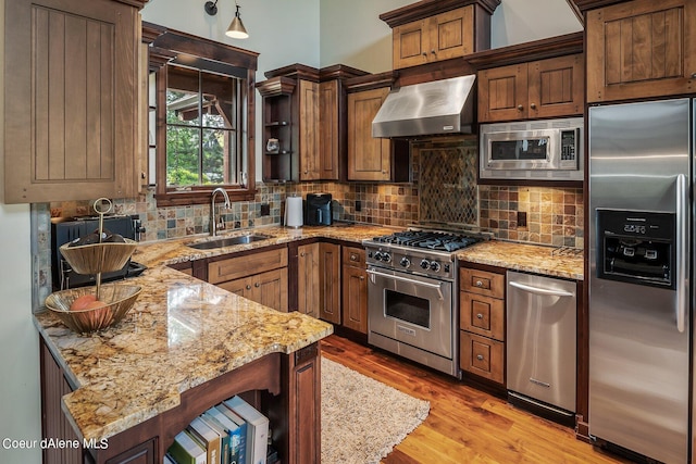 17021 S Citrine Dr, Coeur Dalene, ID 83814 - kitchen featuring stainless steel appliances, a sink, backsplash, wall chimney range hood, and light stone countertops