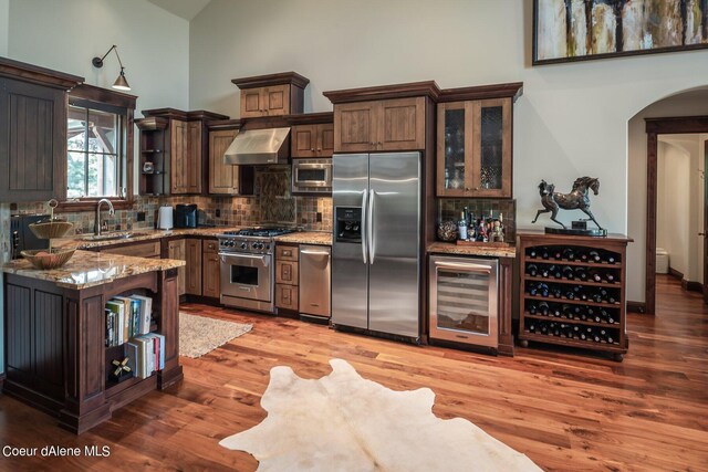 17021 S Citrine Dr, Coeur Dalene, ID 83814 - kitchen with high vaulted ceiling, wall chimney range hood, open shelves, beverage cooler, and appliances with stainless steel finishes