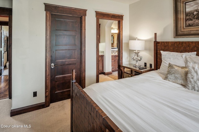 17021 S Citrine Dr, Coeur Dalene, ID 83814 - bedroom featuring arched walkways, ensuite bath, baseboards, and light carpet
