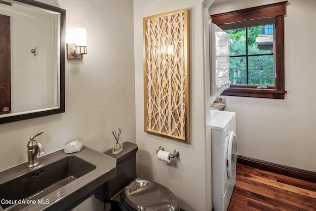 17021 S Citrine Dr, Coeur Dalene, ID 83814 - bathroom featuring toilet, wood finished floors, stacked washer and clothes dryer, and a sink