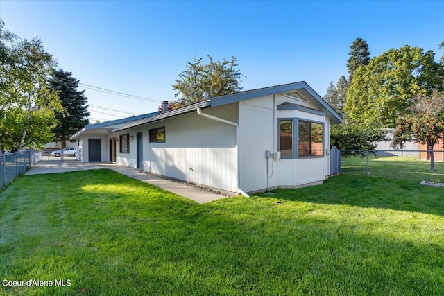 view of side of property featuring a lawn and a patio area