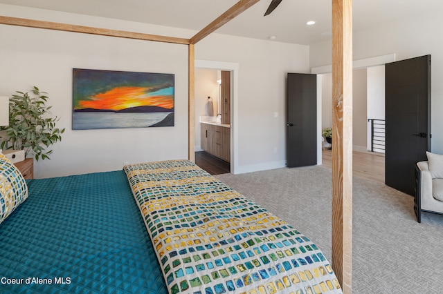 carpeted bedroom featuring ceiling fan, ensuite bath, and sink