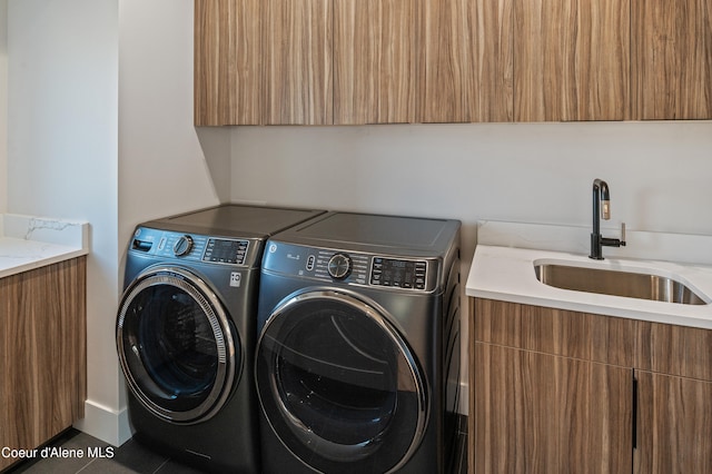 washroom with separate washer and dryer, sink, and cabinets