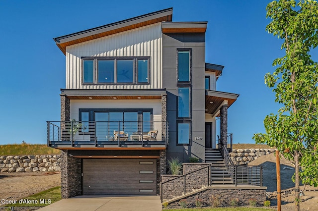 2747 W Lumber Ln, Coeur Dalene, ID 83814 - contemporary home with a garage, driveway, stairway, a balcony, and board and batten siding