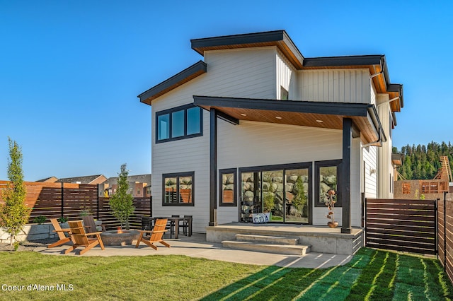 back of house with a yard, a fire pit, and a patio