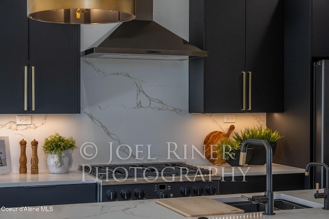 kitchen with light stone counters and wall chimney exhaust hood