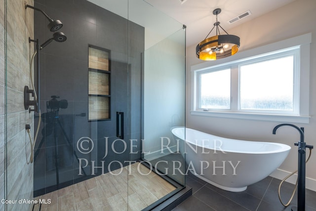 bathroom with tile patterned flooring and separate shower and tub