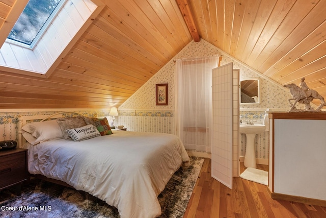 bedroom with hardwood / wood-style flooring, vaulted ceiling with beams, sink, and wood ceiling