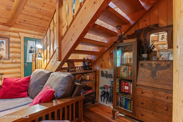 living room featuring wooden ceiling, hardwood / wood-style floors, lofted ceiling with beams, and rustic walls