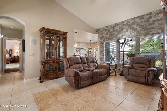 tiled living room with an inviting chandelier and high vaulted ceiling